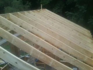 New roof rafters set over an addition before sheathing in New Salem