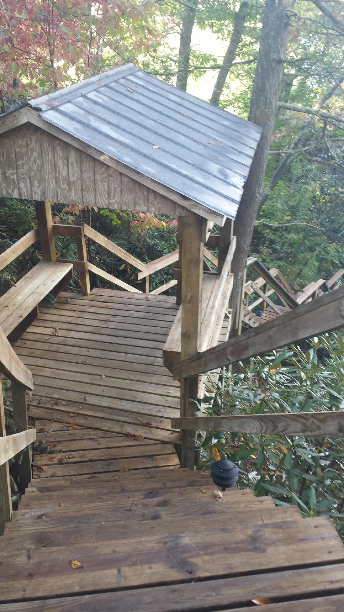 Metal roofed shelter over wooden steps on a wooded walkway — Skylight Repair & Installation work by our crew in New Salem